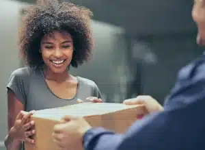A woman receiving a package from Annie's Publishing sent through OSM