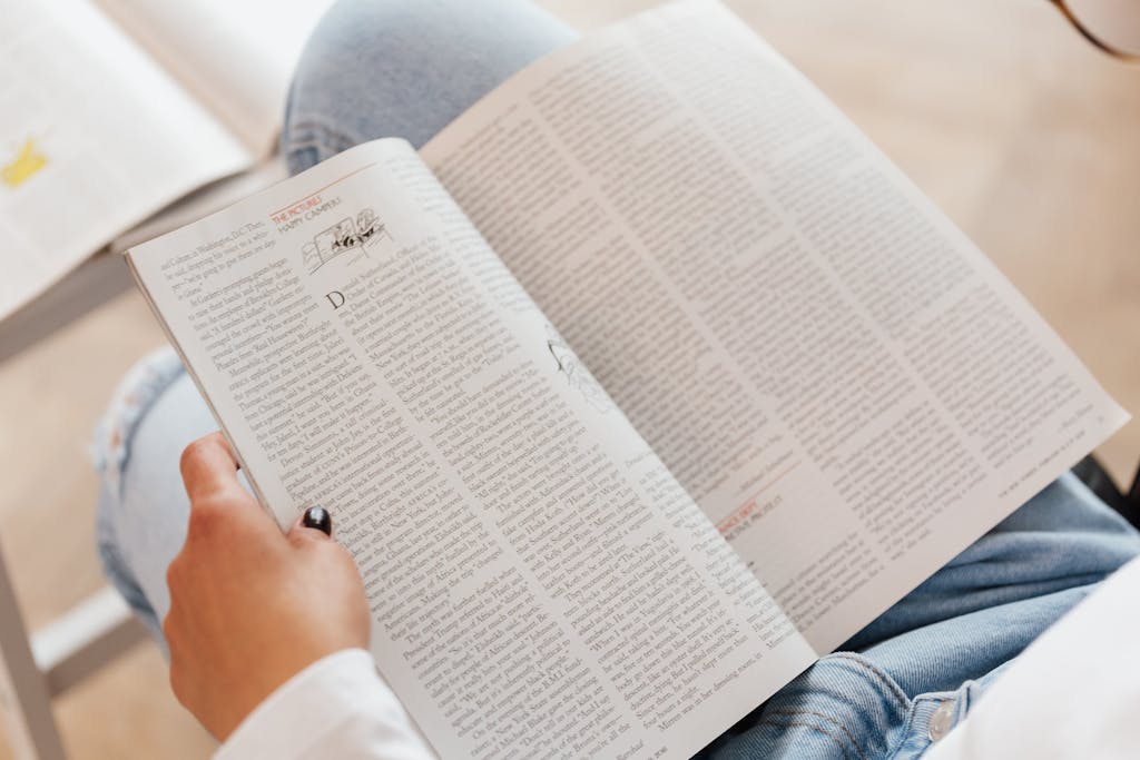 A woman enjoys reading a magazine in a cozy indoor setting, showcasing leisure time and relaxation.