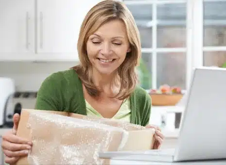 A woman opening a box from PulseTV received through OSM