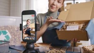A young woman promoting her parcel via social media.